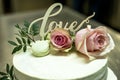 Beautiful wedding cake with cream With text Love on top pink flowers roses Royalty Free Stock Photo