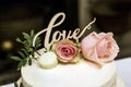 Beautiful wedding cake with cream With text Love on top pink flowers roses Royalty Free Stock Photo