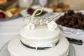 Beautiful wedding cake with cream With text Love on top white flowers roses Royalty Free Stock Photo