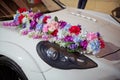 Decorated with flowers as for a wedding . Fresh flowers on the car. Beautiful wedding bouquet on white wedding car . Beautiful Royalty Free Stock Photo