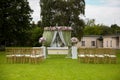 Beautiful wedding ceremony outdoors. Decorated chairs stand on the grass. rustic style. Royalty Free Stock Photo