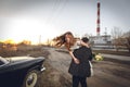 Beautiful wedding couple in the countryside next to the retro car. man groom is taking holding bride in his arms. smiling happy ch Royalty Free Stock Photo