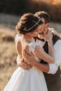 Beautiful wedding couple laughing and kissing against the background of stones. Royalty Free Stock Photo