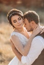 Beautiful wedding couple laughing and kissing against the background of stones. Royalty Free Stock Photo