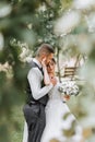 A beautiful wedding, a beautiful couple in love, laughing and kissing against the background of a green garden Royalty Free Stock Photo