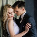 Beautiful wedding couple. Luxurious dress of the bride and stylish suit of the groom, studio photo shoot Royalty Free Stock Photo