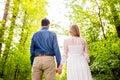 Beautiful wedding couple outside in green forest. Rear view. Royalty Free Stock Photo