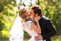 Beautiful wedding couple in park. They kiss and hug each other Royalty Free Stock Photo