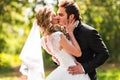 Beautiful wedding couple in park. They kiss and hug each other Royalty Free Stock Photo