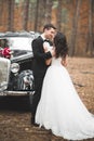 Beautiful wedding couple posing near splendid retro car Royalty Free Stock Photo