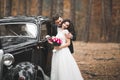 Beautiful wedding couple posing near splendid retro car Royalty Free Stock Photo