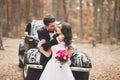 Beautiful wedding couple posing near splendid retro car Royalty Free Stock Photo