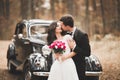 Beautiful wedding couple posing near splendid retro car Royalty Free Stock Photo