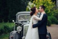 Beautiful wedding couple posing near splendid retro car Royalty Free Stock Photo