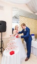 Beautiful wedding couple is pouring champagne indoors. Beauty of bridal interior for marriage. Royalty Free Stock Photo