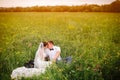 Beautiful wedding couple sitting on the meadow. Copyspace in right Royalty Free Stock Photo