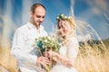 Beautiful wedding couple walking on field, bride and groom posing on wheat field with blue sky Royalty Free Stock Photo