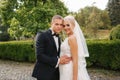 Beautiful wedding couple walking in the park. Bride with long white dress and stylish groom