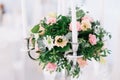 Beautiful wedding floral decoration on a table in a restaurant. White tablecloths, bright room, candles, close-up shooting. The ev Royalty Free Stock Photo