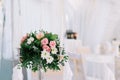 Beautiful wedding floral decoration on a table in a restaurant. White tablecloths, bright room, candles, close-up shooting. The ev Royalty Free Stock Photo