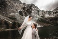 Beautiful wedding photosession. The groom circles his young bride, on the shore of the lake Morskie Oko. Poland Royalty Free Stock Photo