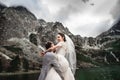 Beautiful wedding photosession. The groom circles his young bride, on the shore of the lake Morskie Oko. Poland Royalty Free Stock Photo