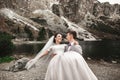 Beautiful wedding photosession. The groom circles his young bride, on the shore of the lake Morskie Oko. Poland Royalty Free Stock Photo