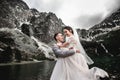 Beautiful wedding photosession. The groom circles his young bride, on the shore of the lake Morskie Oko. Poland Royalty Free Stock Photo