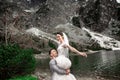 Beautiful wedding photosession. The groom circles his young bride, on the shore of the lake Morskie Oko. Poland Royalty Free Stock Photo