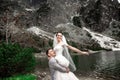 Beautiful wedding photosession. The groom circles his young bride, on the shore of the lake Morskie Oko. Poland Royalty Free Stock Photo