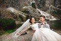 Beautiful wedding photosession. The groom circles his young bride, on the shore of the lake Morskie Oko. Poland Royalty Free Stock Photo