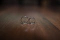 Beautiful wedding rings lie on a wooden surface