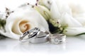 Beautiful wedding rings on a light background, which are adorned with flowers. Rings are a symbol of marriage and love.