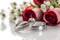 Beautiful wedding rings on a light background, which are adorned with flowers. Rings are a symbol of marriage and love.