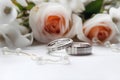 Beautiful wedding rings on a light background, which are adorned with flowers. Rings are a symbol of marriage and love.