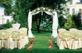 Beautiful wedding set up. Area of the wedding ceremony. Round arch, white chairs decorated with flowers, greenery. Cute, trendy