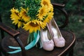 Beautiful wedding shoes with high heels and a bouquet of sunflowers on a vintage chair Royalty Free Stock Photo