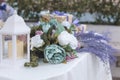 Beautiful wedding tabletop decoration. With sage green, blush, lavender and white colored roses and white candle lantern