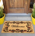 Beautiful welcome peach color coir doormat with flower border Placed outside door with green leaves