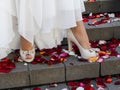 Beautiful well-groomed female legs with a pedicure in beige open shoes with heels stand on the steps of the stairs Royalty Free Stock Photo