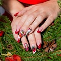 Beautiful well-groomed hands of a young girl with long fake acrylic nails with a festive Christmas pattern on the nails Royalty Free Stock Photo