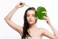 Wet young woman posing with green palm leaf with water drops isolated on white Royalty Free Stock Photo