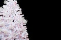 Beautiful white artificial tree with red and silver ornaments. Isolated on black background