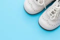 White baby shoes on blue background Royalty Free Stock Photo