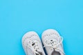 White baby shoes on blue background Royalty Free Stock Photo