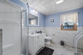 Beautiful white blue bathroom interior with white furniture and a window to a park Royalty Free Stock Photo