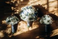 Beautiful white and blue roses wedding bouquets for bride and bridesmaids closeup, fresh white flowers bouquet on wooden