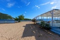 Beautiful white-blue wooden restaurant standing on a sandy beach in the background of the sea and a small tree Royalty Free Stock Photo