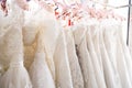 Beautiful, White bridal dress texture on background. Wedding dresses hanging on a hanger interior of bridal salon. Design, fashion