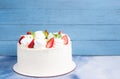 Beautiful white cake decoraited with meringue and fresh strawberries. Blue  background, copy space Royalty Free Stock Photo